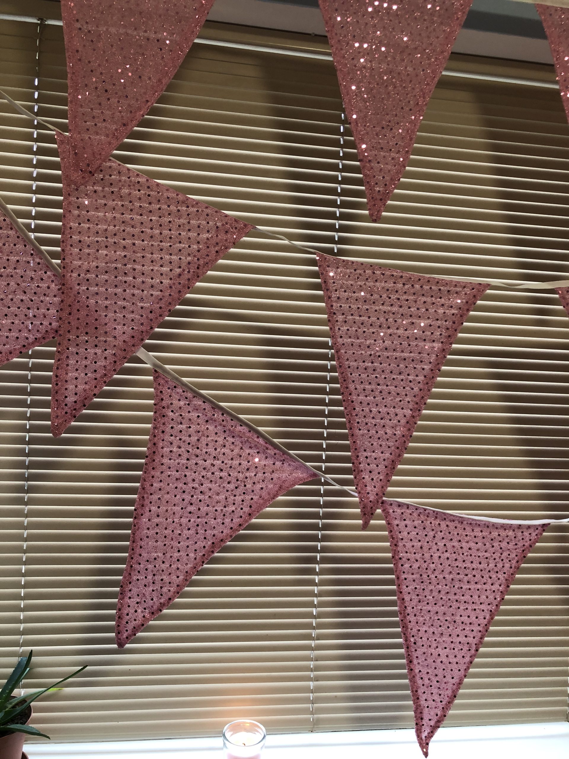 Extra large bunting flags made from pink sparkly sequinned fabric.