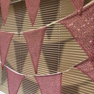 Pink sequinned bunting with extra large flags, made from fabric saved from landfill.
